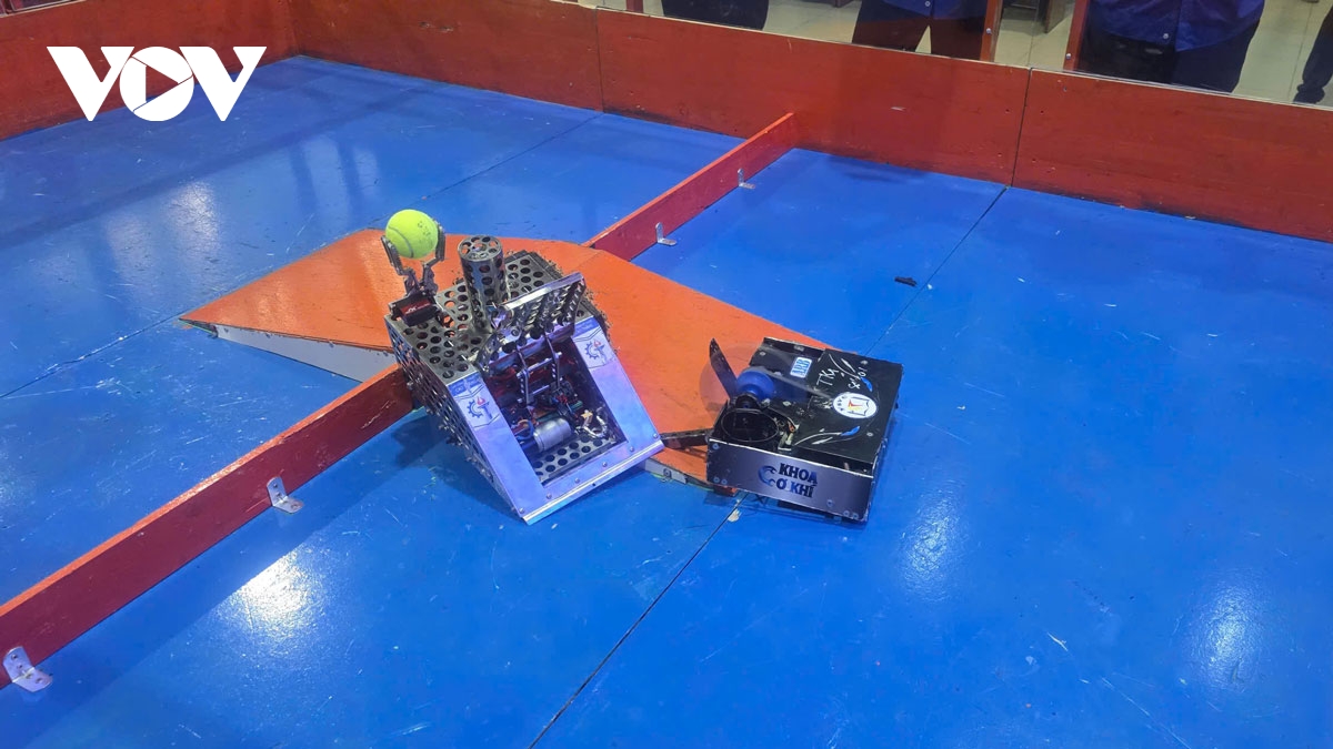 Hai robot đang tranh bóng và đưa bóng về rổ chỉ định để ghi điểm Robot tranh bóng trên sân
