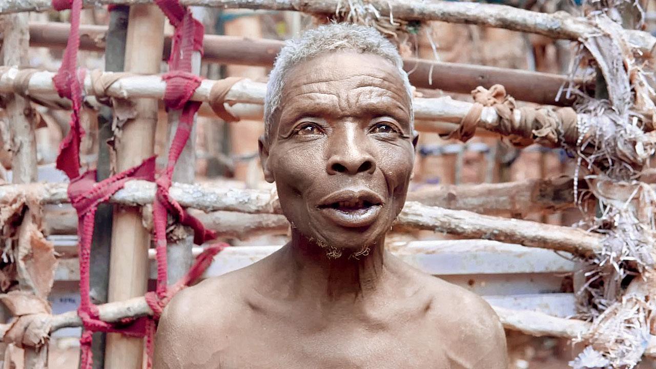 Ông Callitxe Nzamwita bên ngoài căn nhà của mình